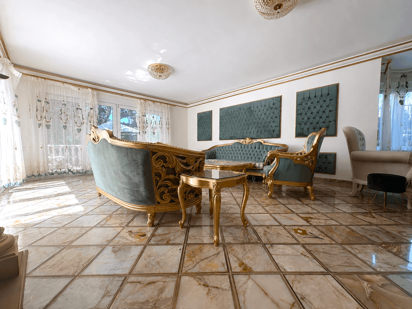 Eleganter Wohnbereich mit opulenten Sitzmöbeln und dekorativen Wandpaneelen.