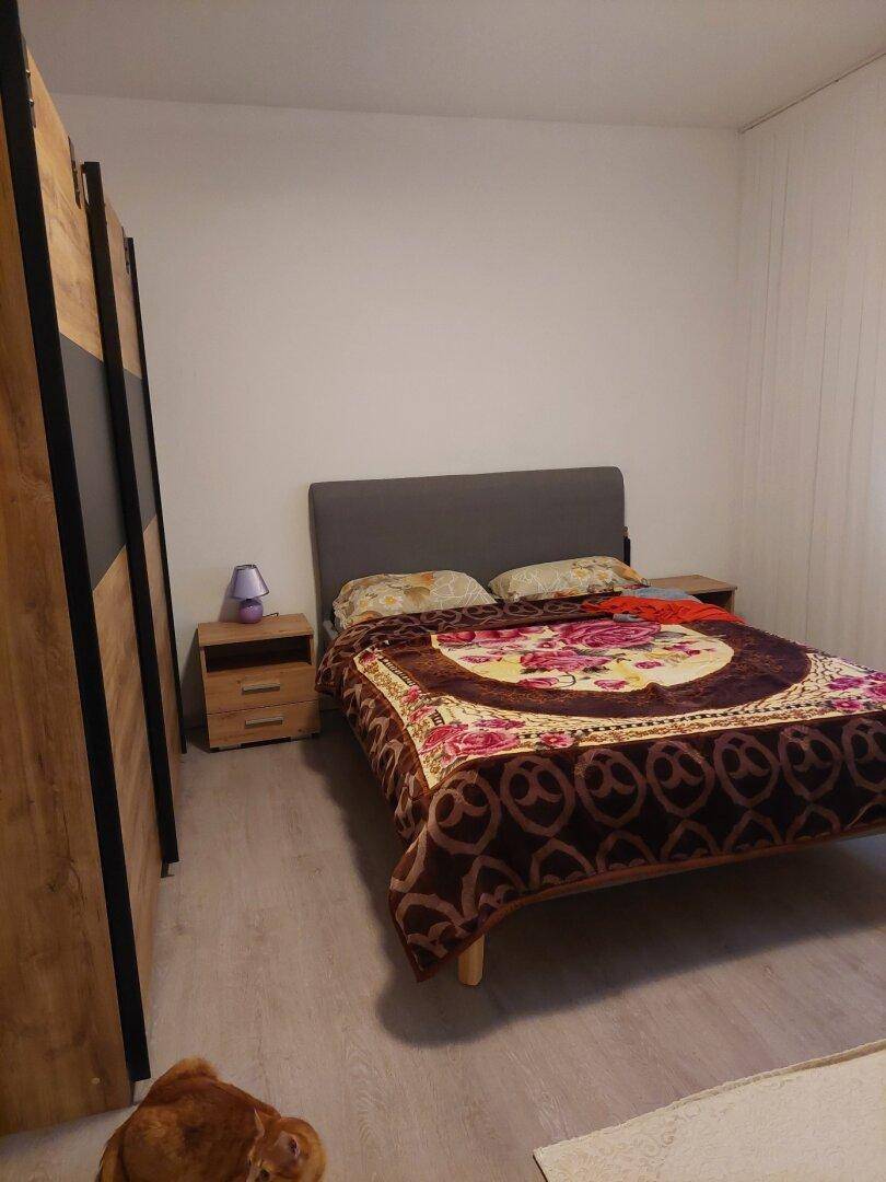 Schlafzimmer mit Doppelbett, Nachttischen und großem Kleiderschrank.