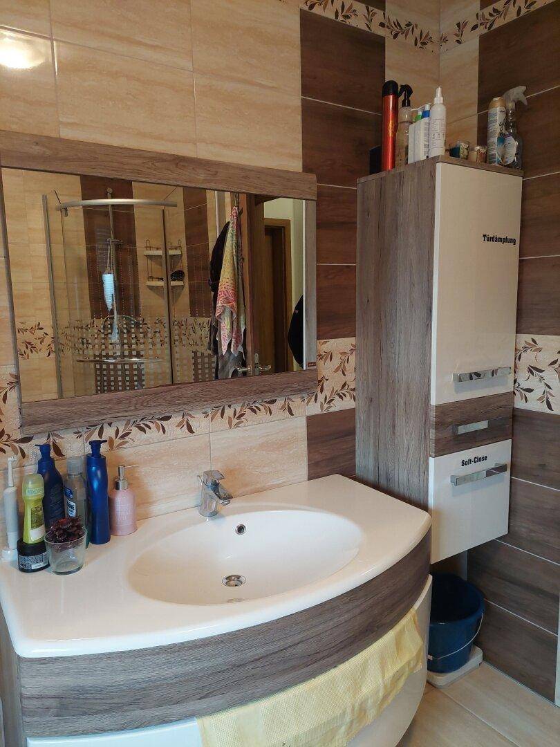 Badezimmer mit Waschbecken, Spiegelschrank und modernem Design.