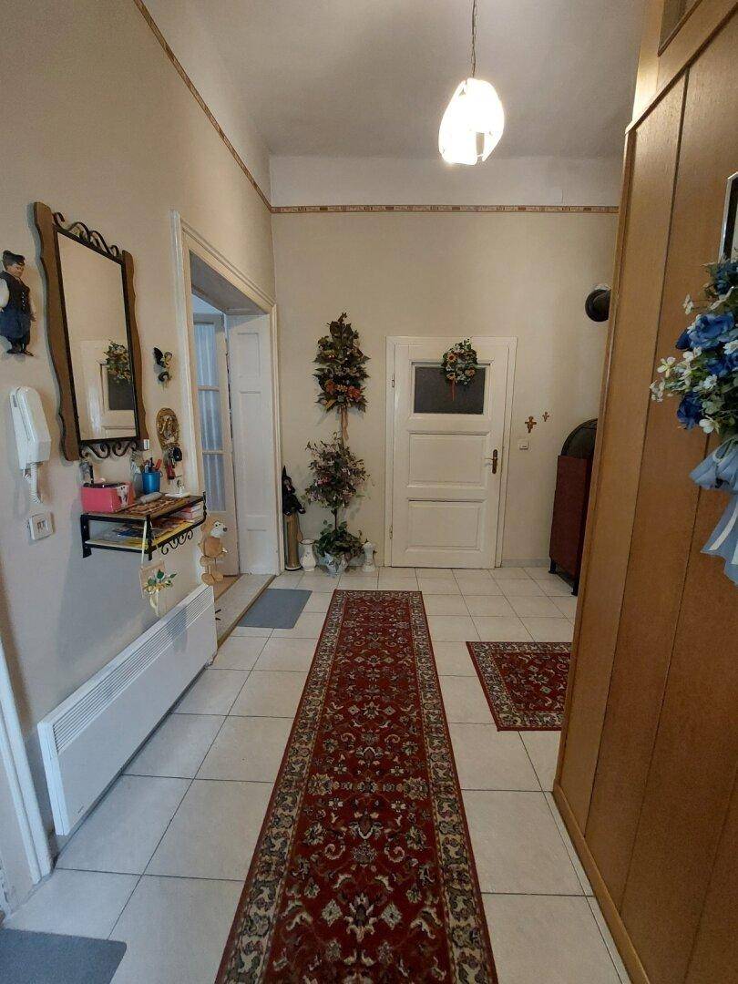 Geräumiger Eingangsbereich mit Fliesenboden, Teppichläufer und Garderobenschrank, einladend gestaltet.