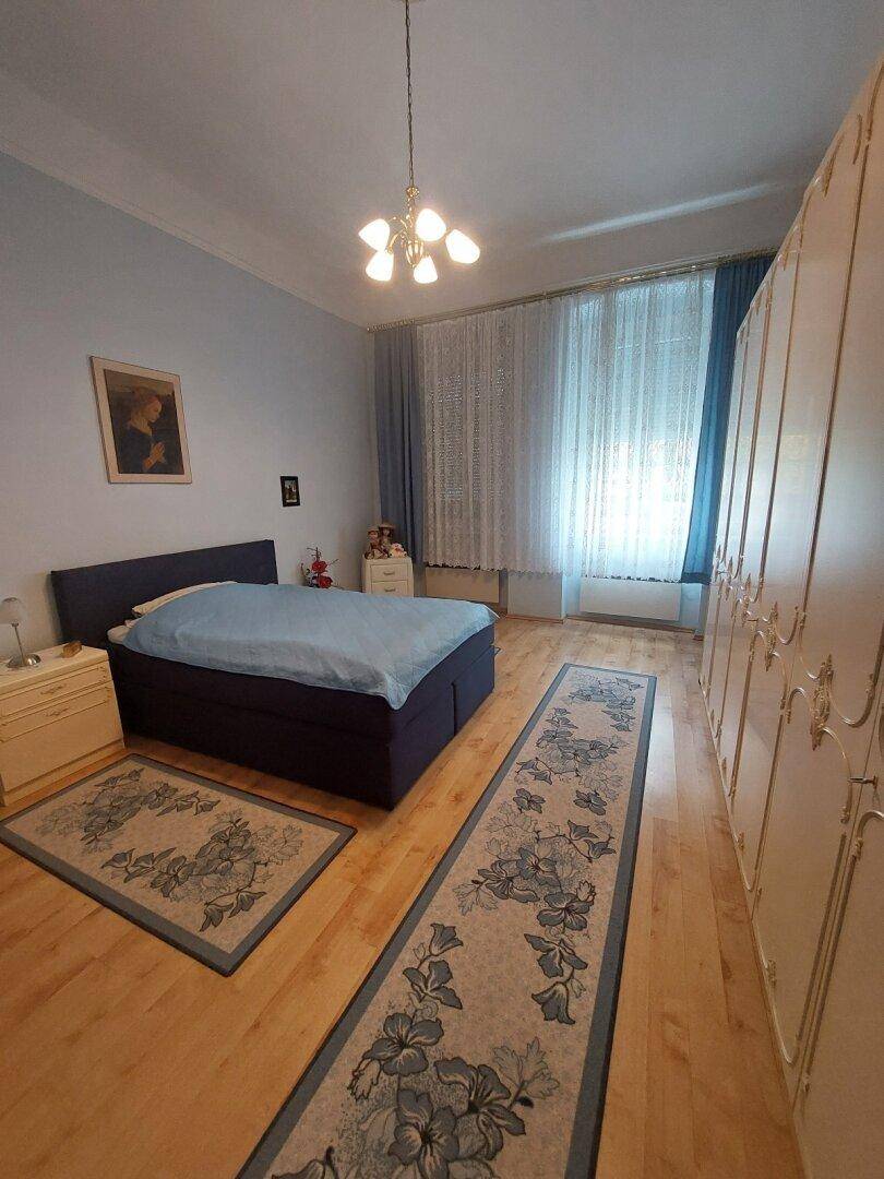 Schlafzimmer mit Doppelbett, großen Kleiderschränken und Holzfußboden, hell und geräumig.