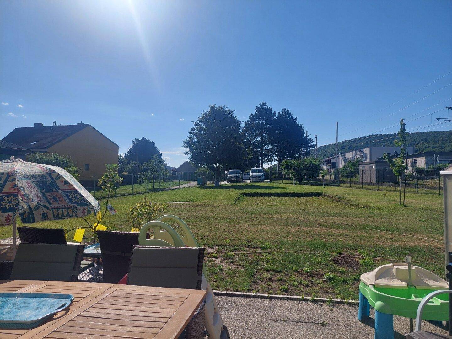 Weitläufiger Blick von der Terrasse über den großen Rasen und die umliegende Landschaft.