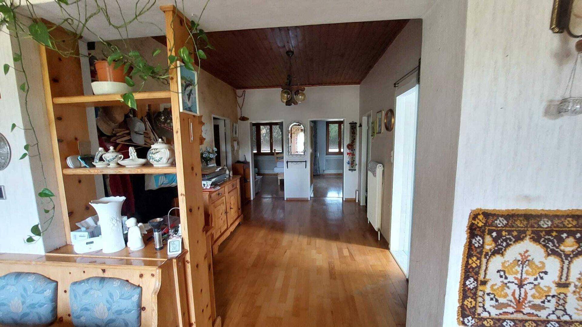 Geräumiger Flur mit Holzboden und Holzdecke, der zu weiteren Räumen führt.