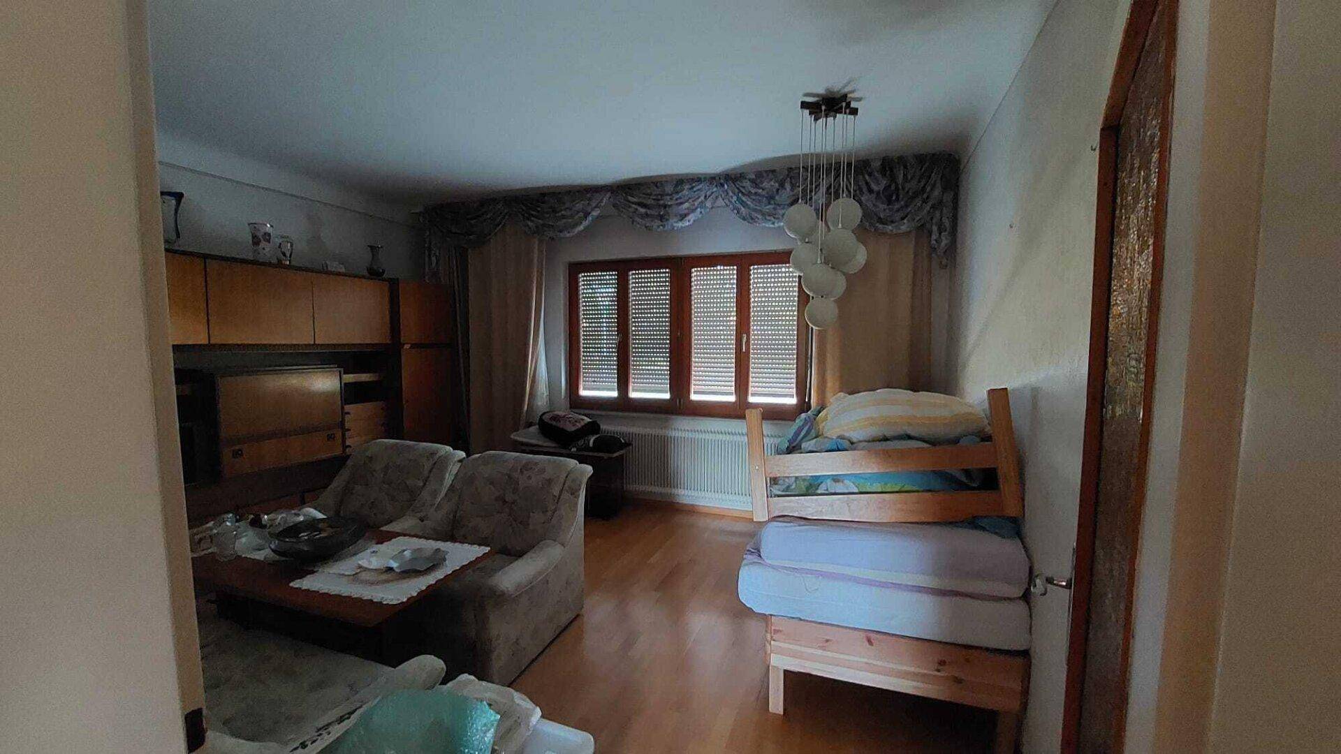 Gemütliches Schlafzimmer mit Holzboden, traditionellen Möbeln und einem Einzelbett.
