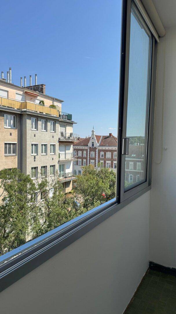 Verglaster Balkon mit Panoramablick auf die Stadt und die umliegende Architektur.