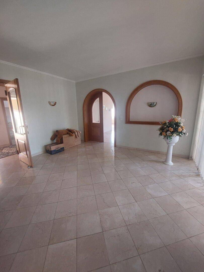 Helles Wohnzimmer mit Fliesenboden und dekorativen Rundbögen als Durchgänge.