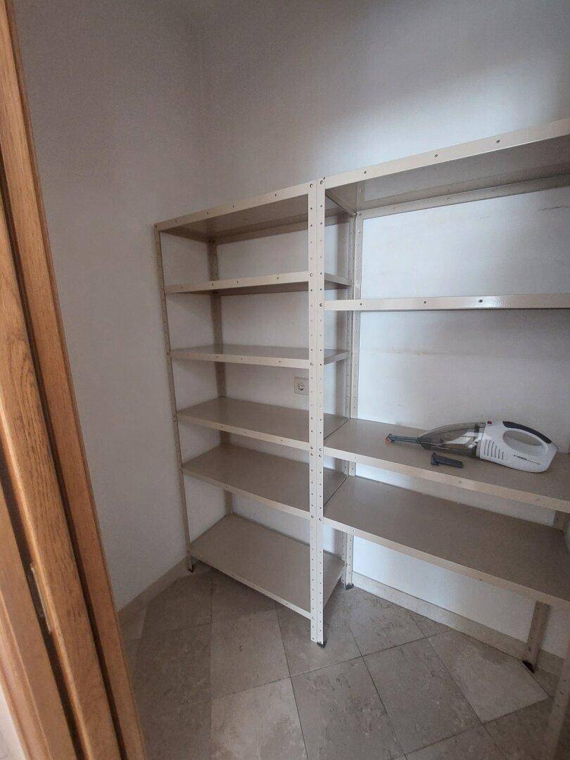 Abstellraum mit Metallregalen und Fliesenboden für zusätzlichen Stauraum.