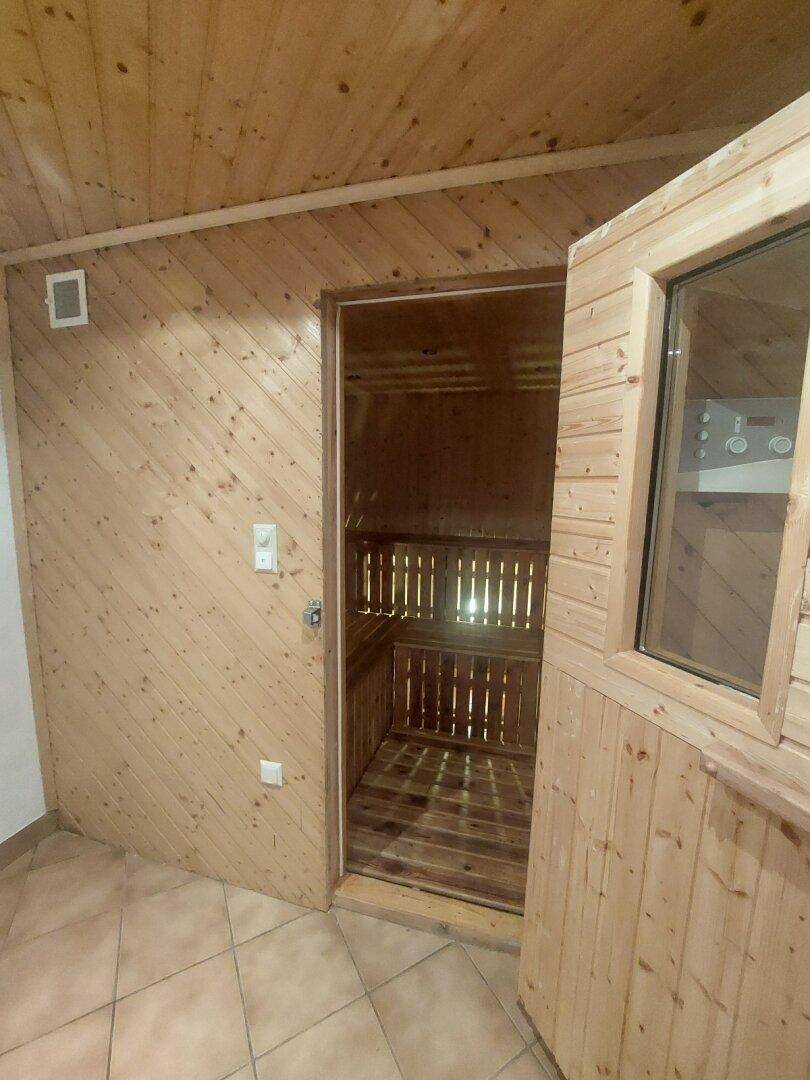 Nahaufnahme der Holzsauna mit bequemen Bänken und Steuerungselementen, bereit für Wellnessmomente.