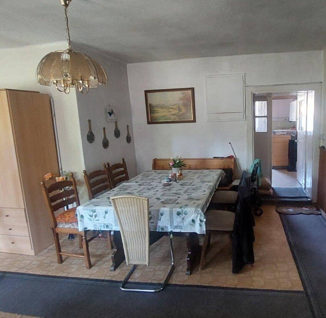 Esszimmer mit großem Holztisch, traditionellen Stühlen und Kronleuchter.