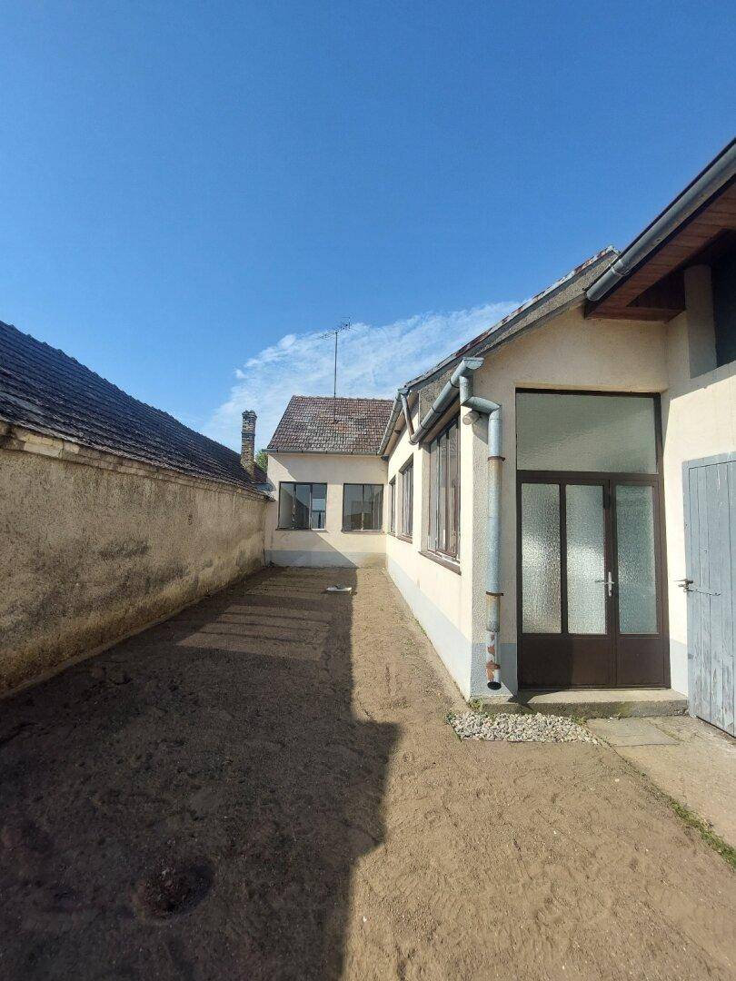 Hinterhofbereich mit vorbereitetem Boden für einen Garten, umgeben von Mauern.