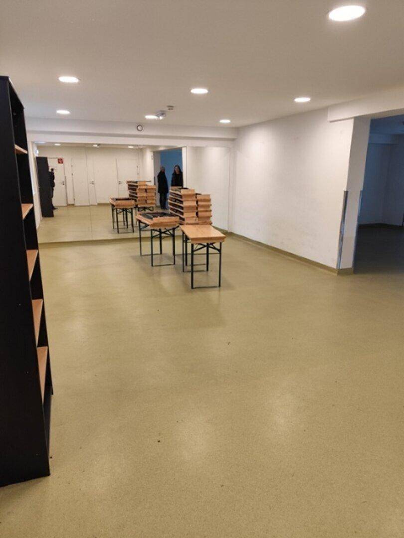 Großer Mehrzweckraum mit Spiegelfront, hellem Boden und Tischen, ideal für Veranstaltungen oder Schulungen.