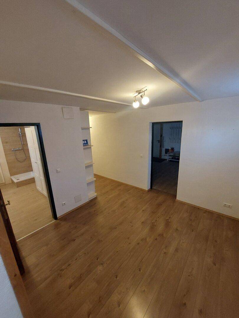 Geräumiger Flur mit Holzboden und Zugang zu verschiedenen Zimmern.