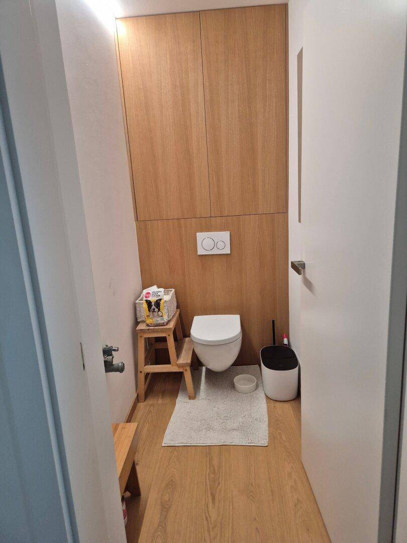 Modernes Gäste-WC mit Holzwandverkleidung und wandhängendem WC.