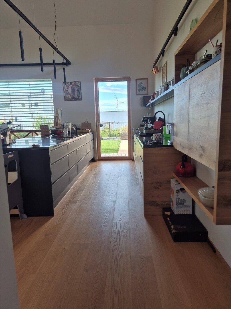 Moderne Küche mit Holzboden und direktem Zugang zum Gartenbereich.