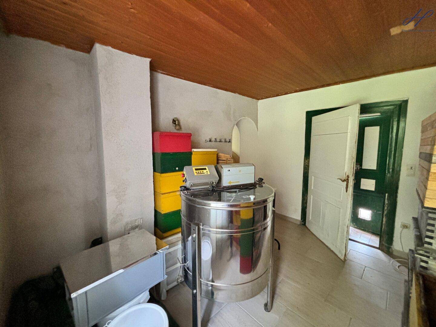 Raum mit industriellen Geräten und Holzbalkendecke, möglicherweise zur Lebensmittelverarbeitung genutzt.