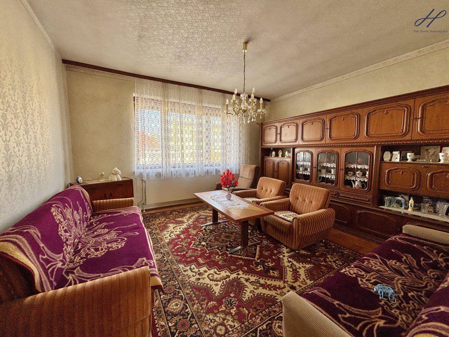 Gemütliches Wohnzimmer mit traditionellen Möbeln und einem großen Teppich.