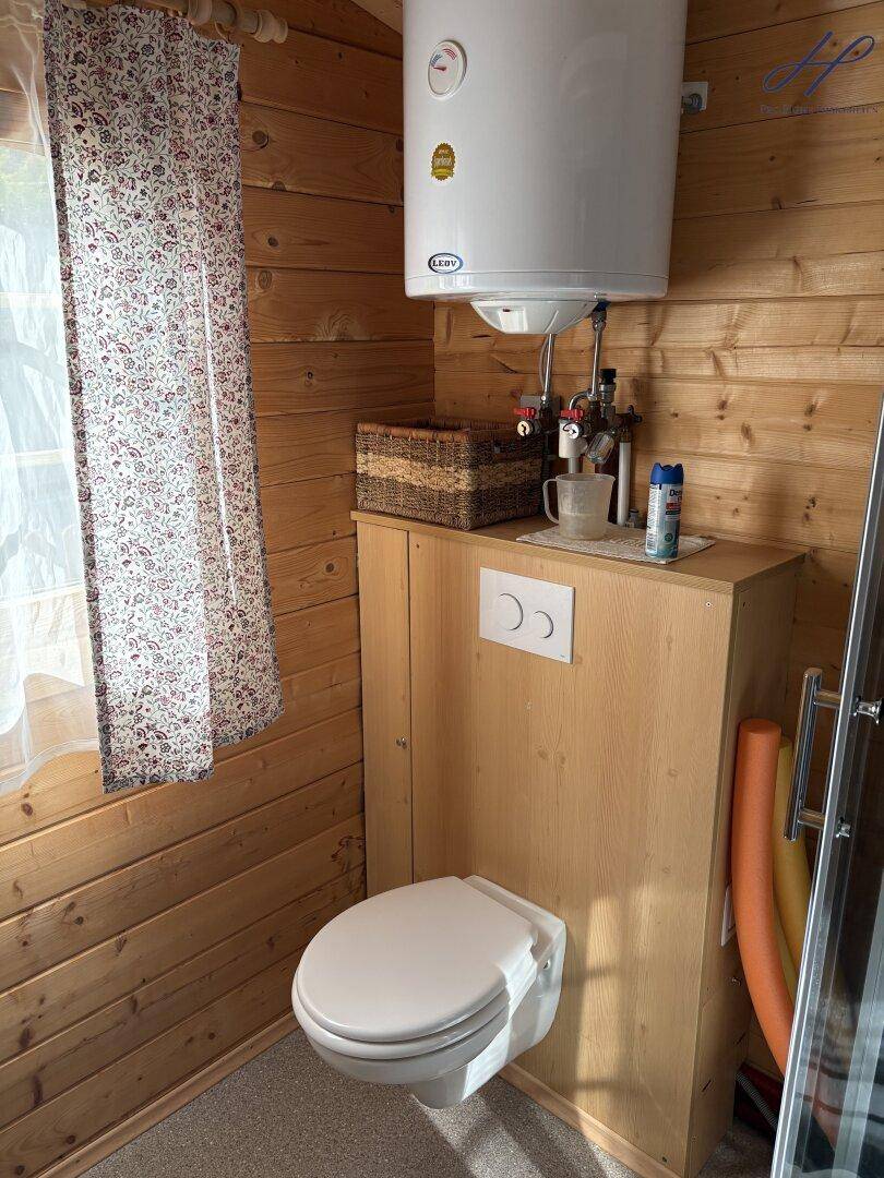 Toilettenbereich im Badezimmer mit Holzwänden und wandhängendem WC.
