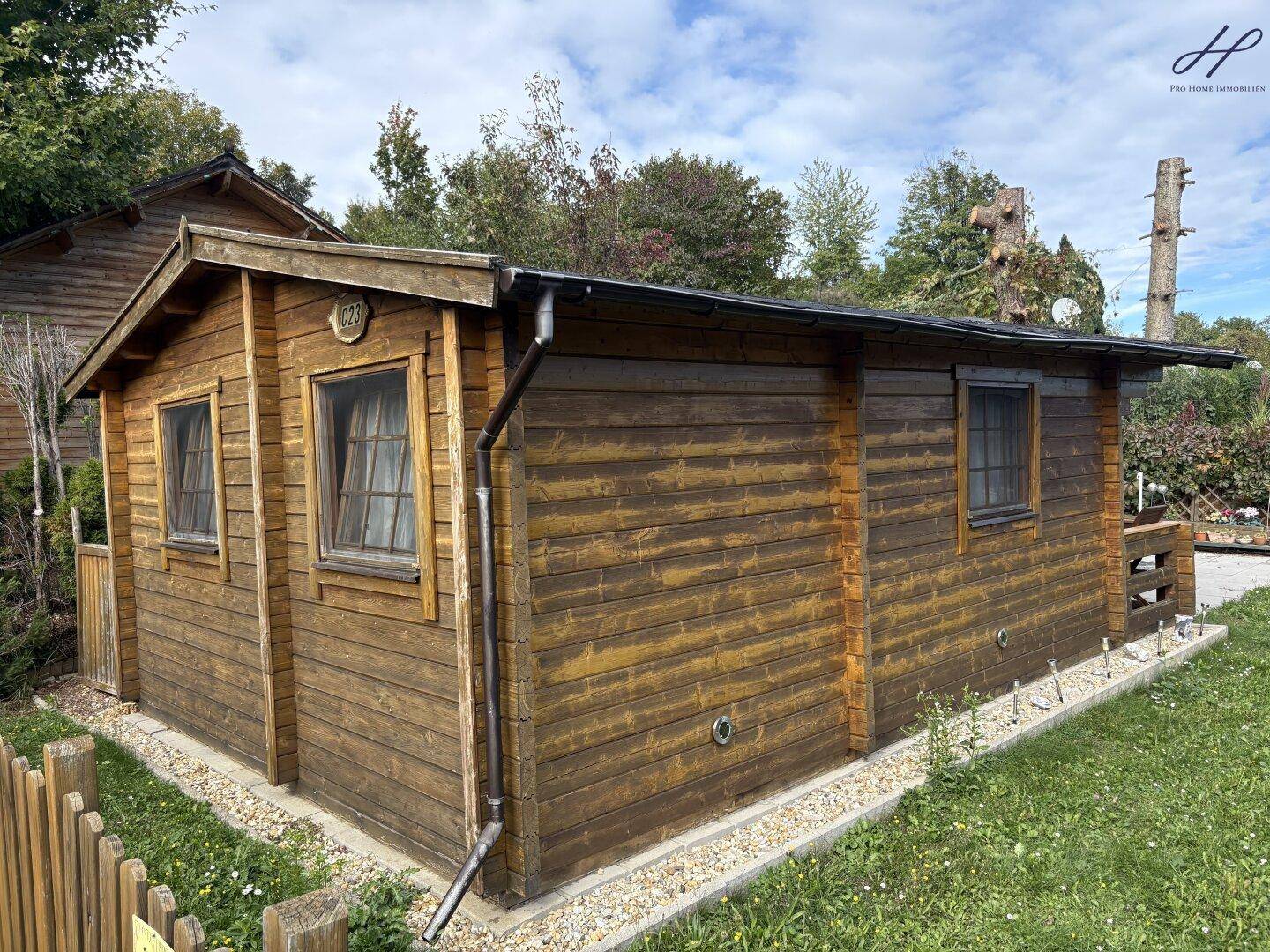 Charmantes Holzhaus im Chalet-Stil mit gepflegter Fassade und kleinen Fenstern.