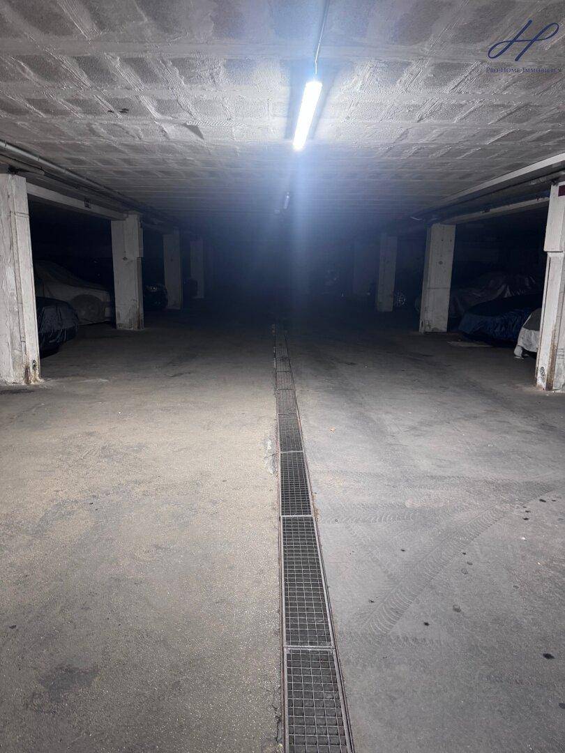 Tiefgarage mit Betonboden und Säulen, bietet Stellplätze für Fahrzeuge.