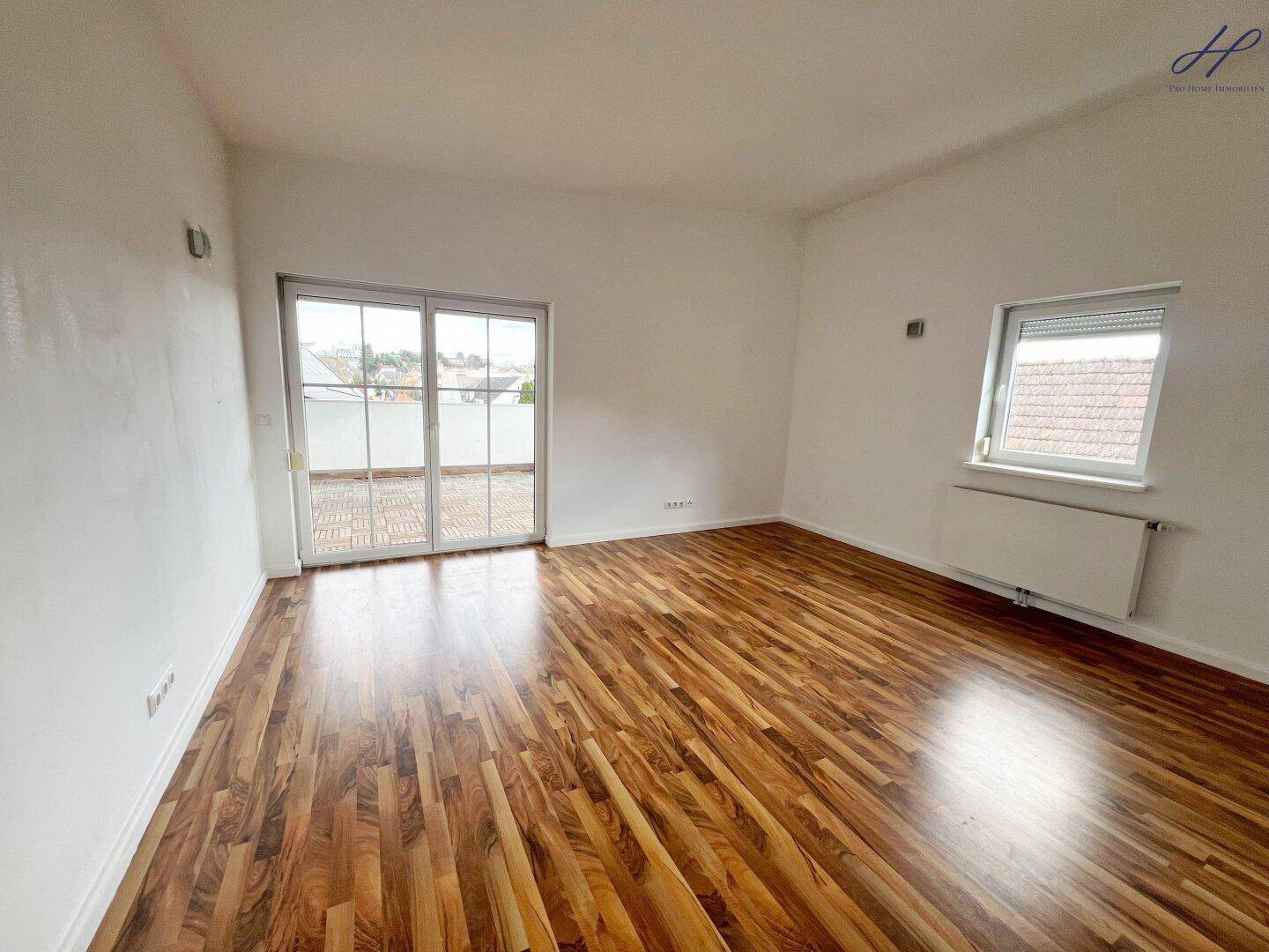 Helles Schlafzimmer mit Holzboden, Fenster und direktem Terrassenzugang für frische Luft.