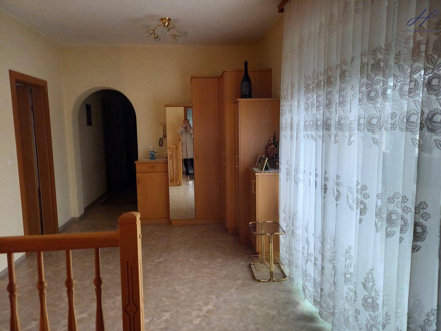 Geräumiger Flur im Obergeschoss mit Schränken und einem großen Fenster.