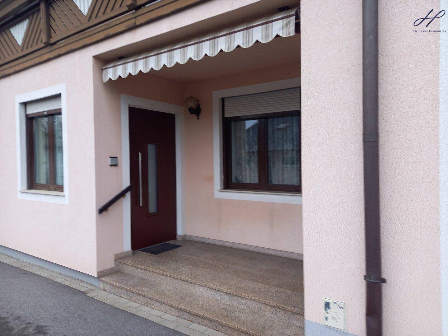 Eingangsbereich des Hauses mit Vordach, Markise und Granitstufen.
