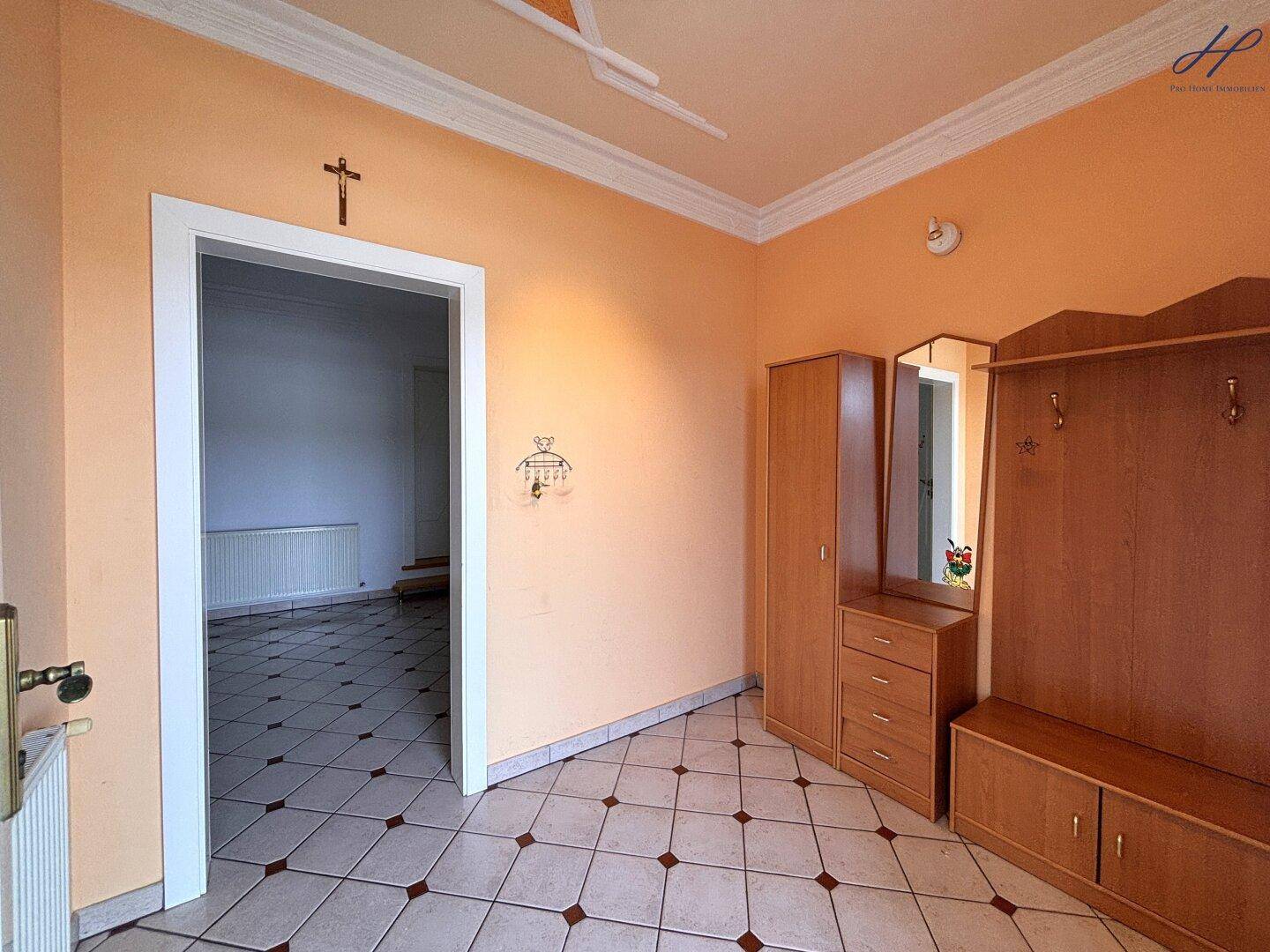 Eingangsbereich mit Fliesenboden, Garderobe und Zugang zu weiteren Räumen.