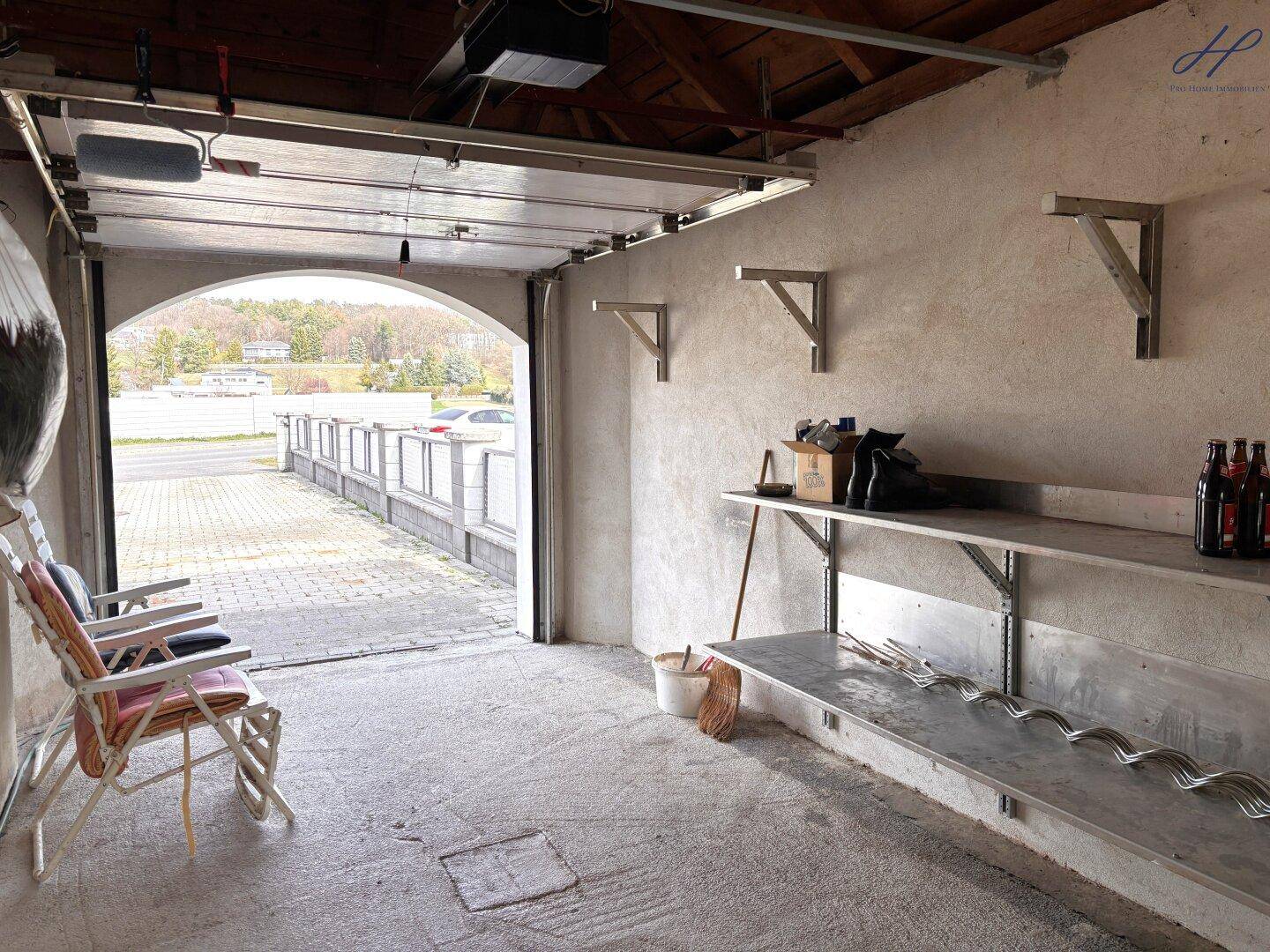 Geräumige Garage mit Regalen und direktem Zugang zur Auffahrt.