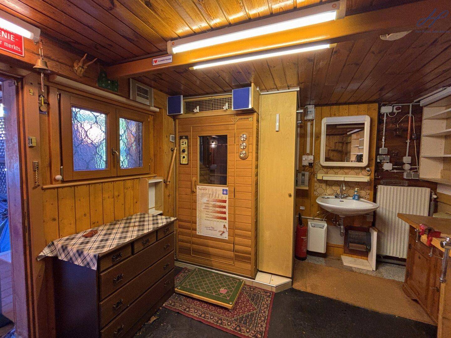 Wellnessbereich mit Sauna, Waschbecken und Holzverkleidung.