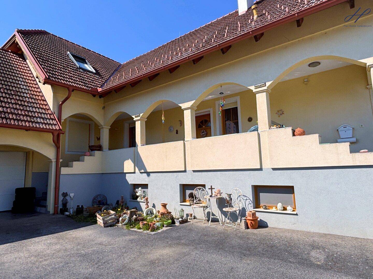Detailansicht der Hausfassade mit dekorativen Bögen und einem kleinen Vorgartenbereich.