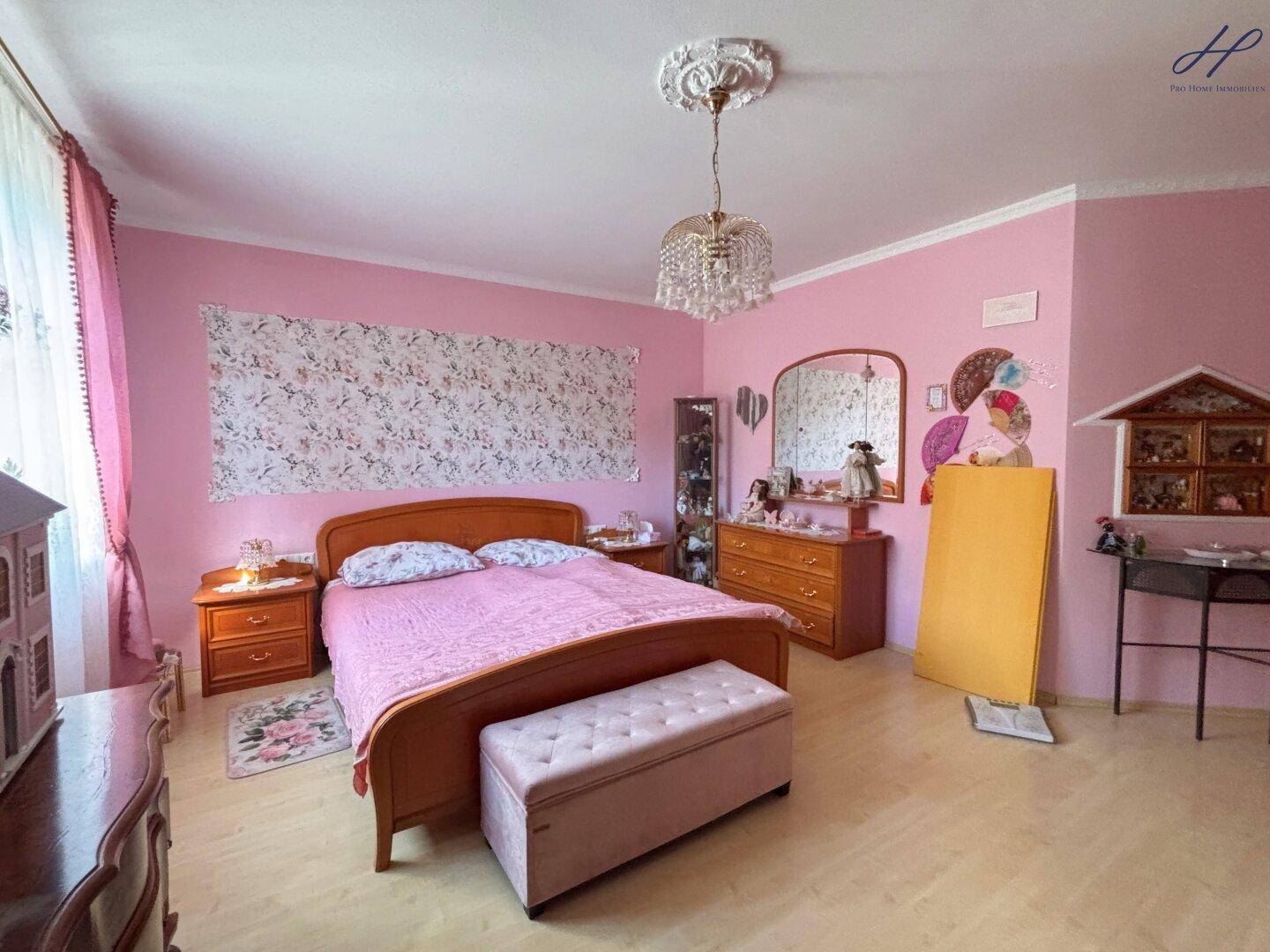 Geräumiges Schlafzimmer mit Doppelbett, Kommoden und dekorativer Wandgestaltung.