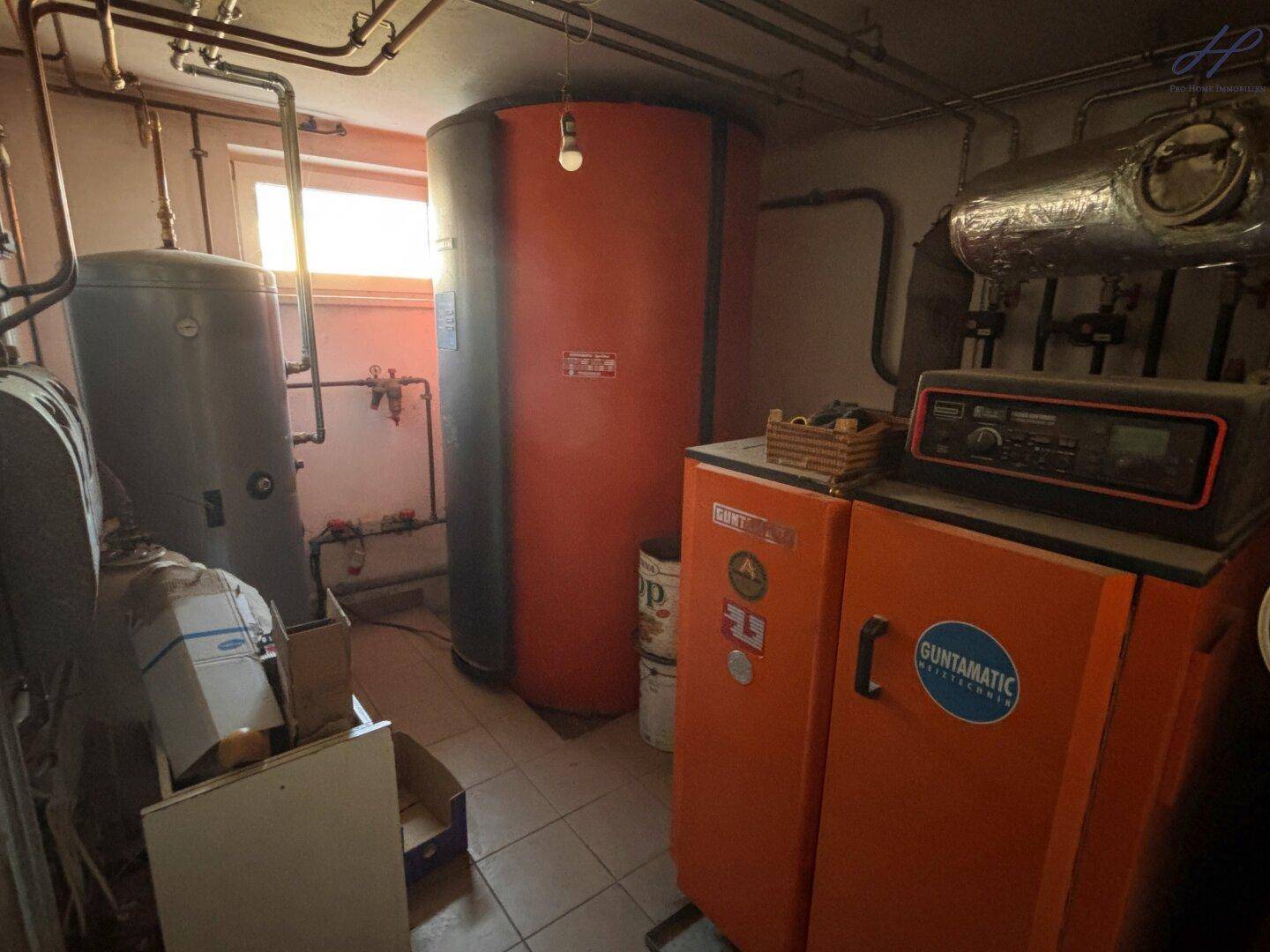 Heizungsraum mit großen Warmwasserspeichern, komplexen Rohrleitungen und Heizungsanlage.