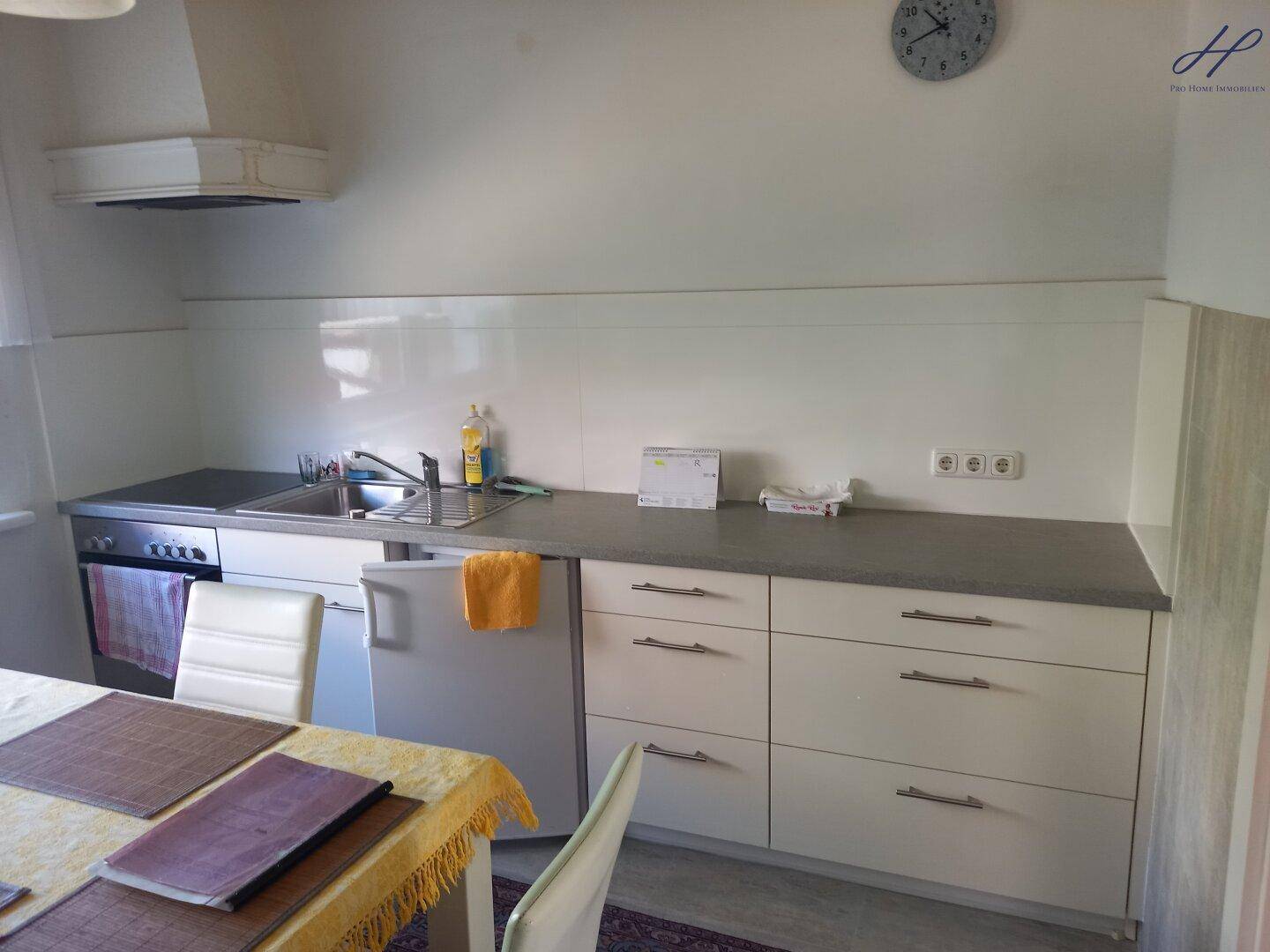 Funktionale Küche mit Spüle, Herd und Kühlschrank, bereit zur Nutzung.