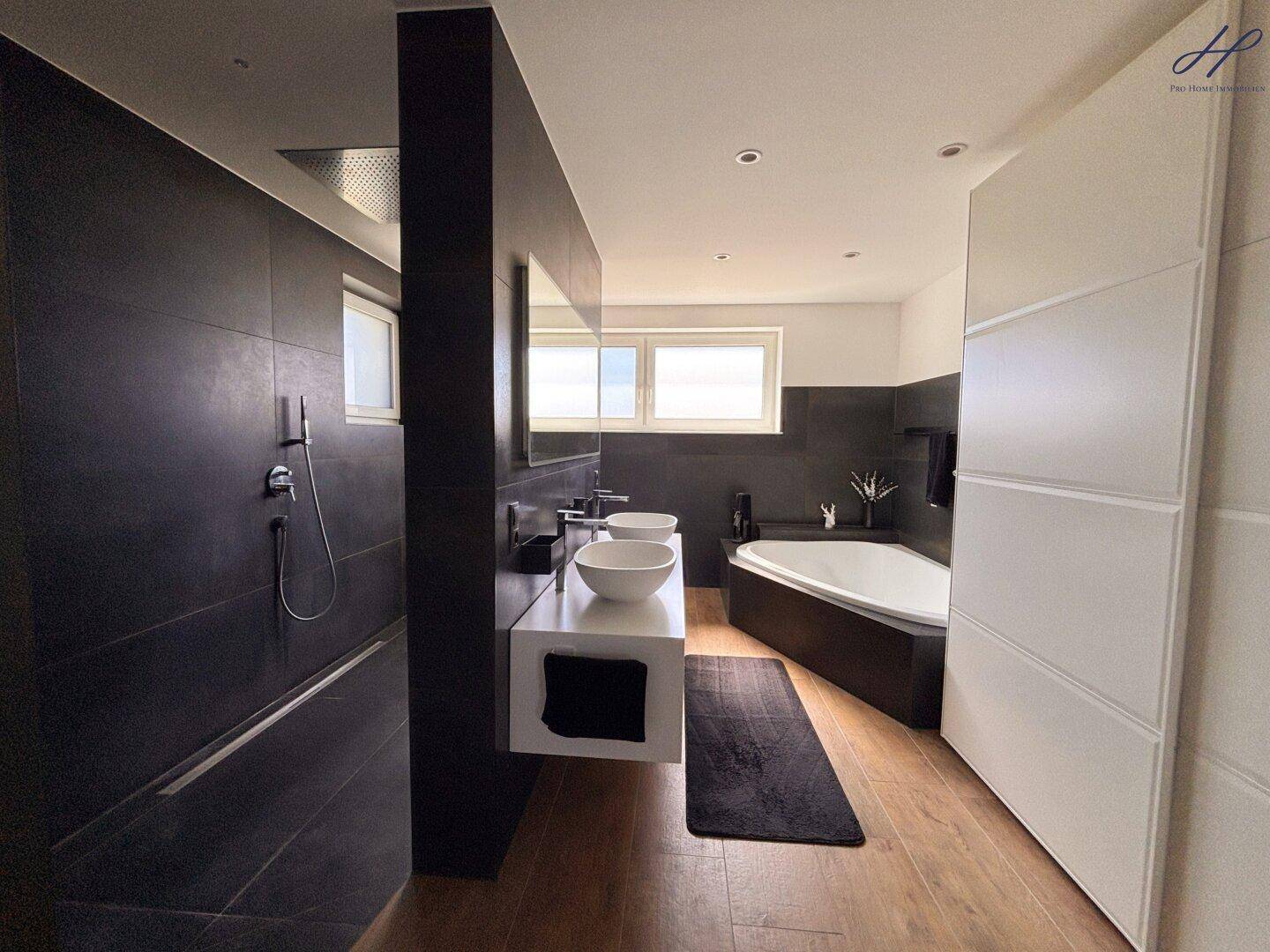 Geräumiges Badezimmer mit Badewanne, begehbarer Dusche und Doppelwaschbecken für höchsten Komfort.