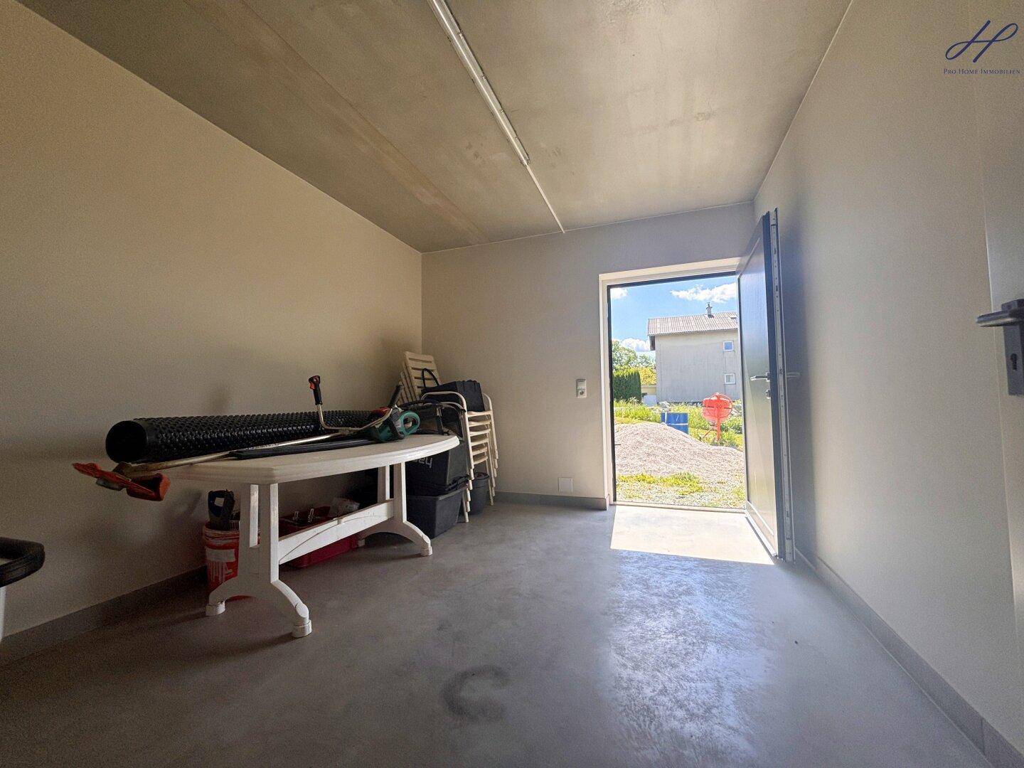 Garage mit direktem Zugang nach draußen und viel Platz für Lagerung oder Hobbyaktivitäten.