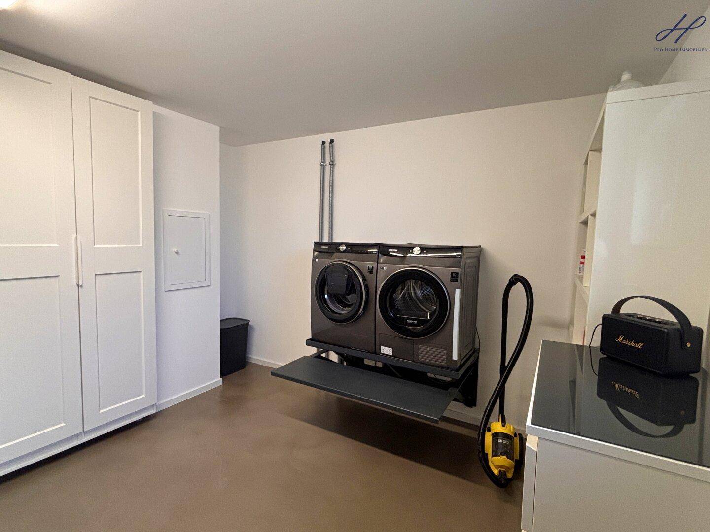 Praktischer Hauswirtschaftsraum mit Waschmaschine, Trockner und Einbauschränken für effiziente Organisation.