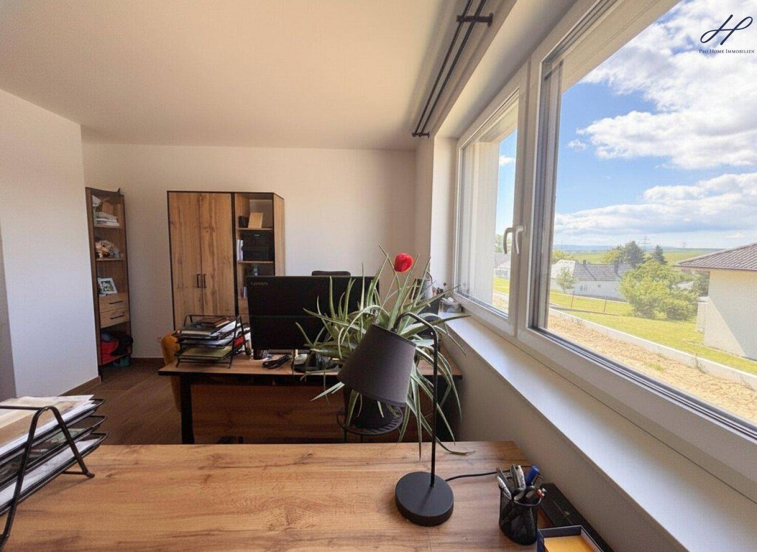 Helles Büro mit Holzschreibtisch, modernen Möbeln und weitem Blick aus dem Fenster.