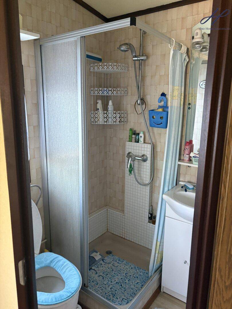 Kleines Badezimmer mit Duschkabine, WC und Waschbecken, funktional und hell gestaltet.