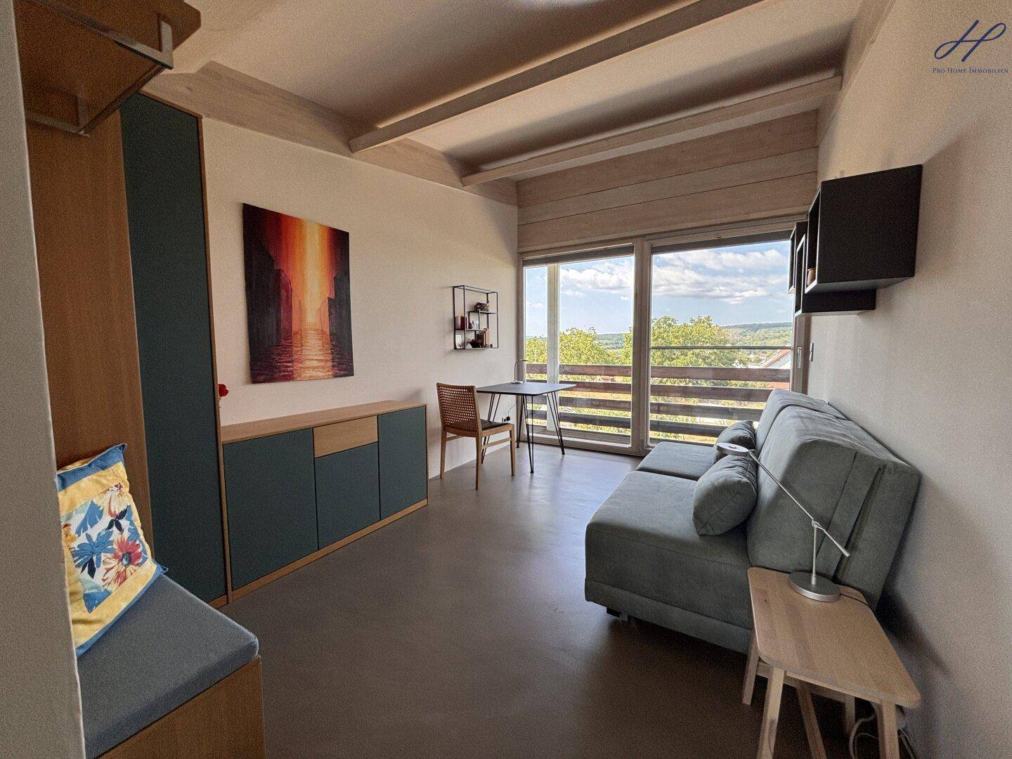Gemütliches Schlafzimmer mit Sofa, modernen Möbeln und Zugang zum Balkon.