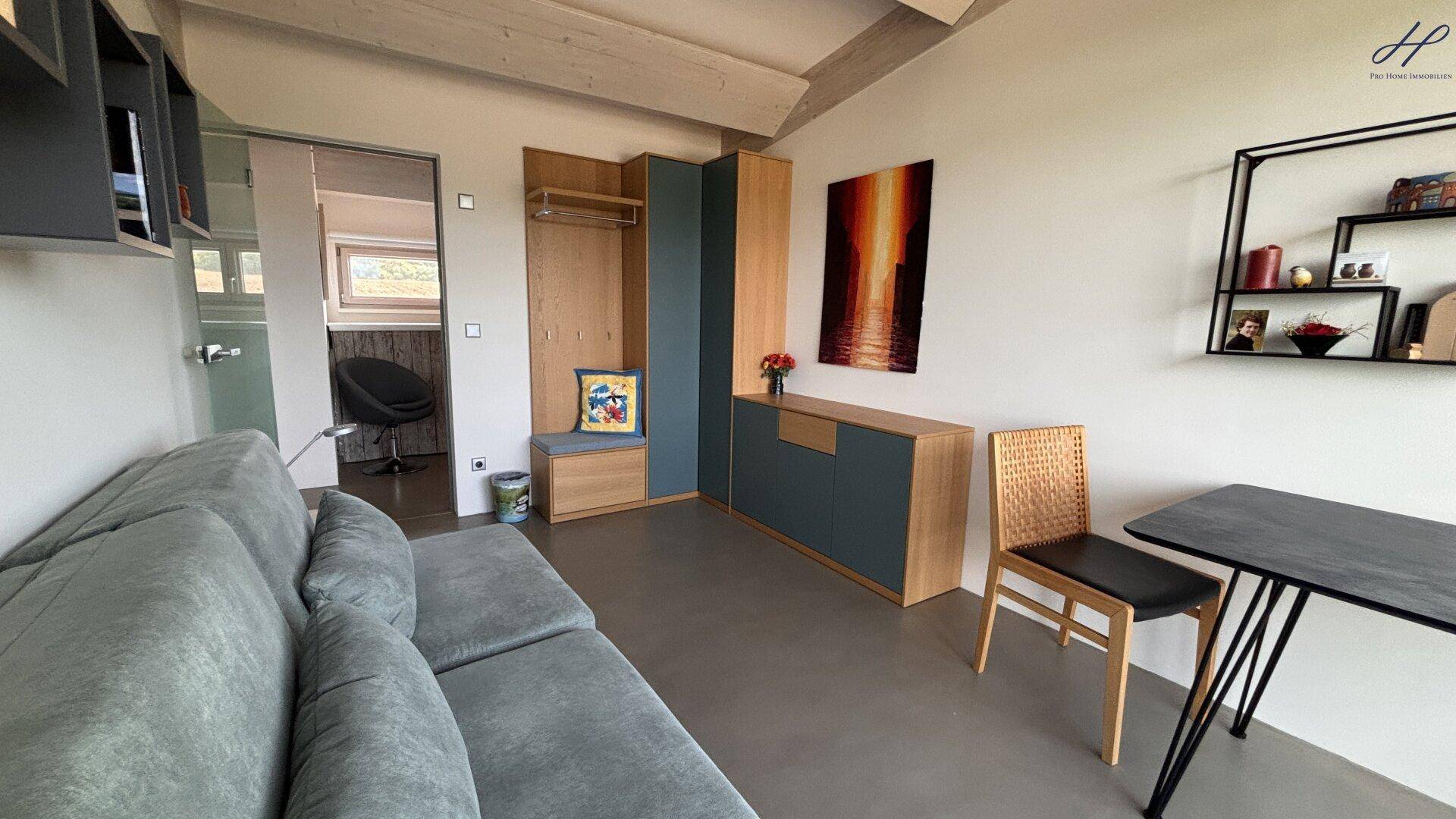 Modern eingerichtetes Schlafzimmer mit Sofa, Stauraum und hellem Ambiente.