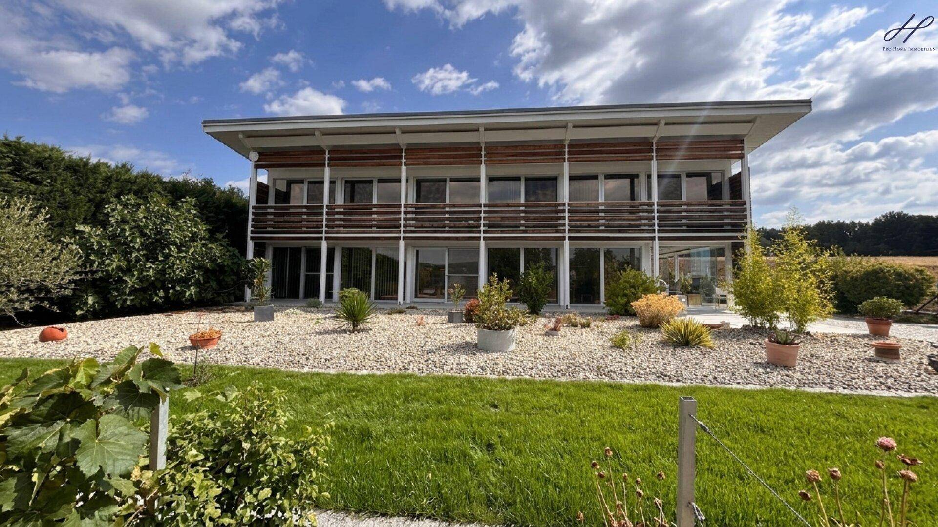 Modernes Wohnhaus mit weitläufigem Garten und Blick auf die Natur.