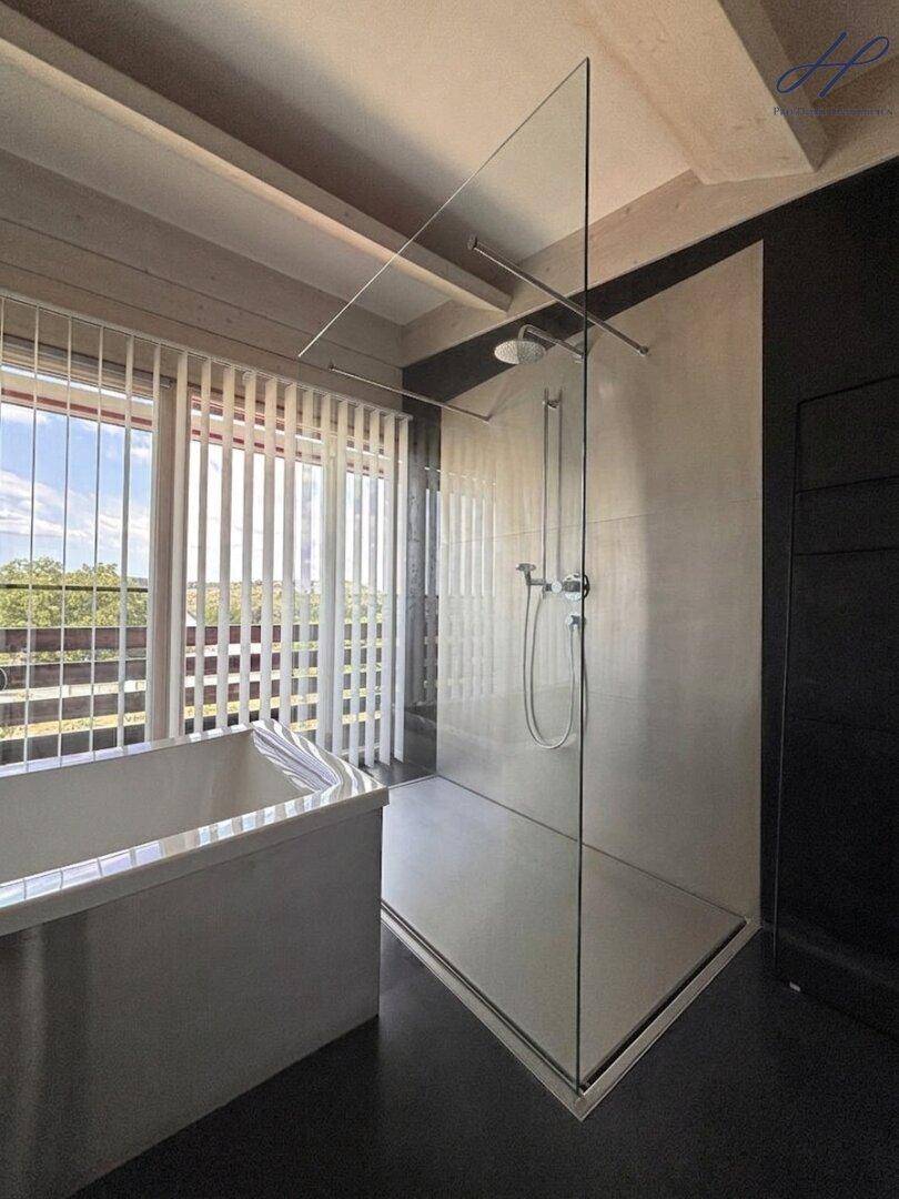 Geräumige begehbare Dusche mit Glaswand in einem modernen Badezimmer.