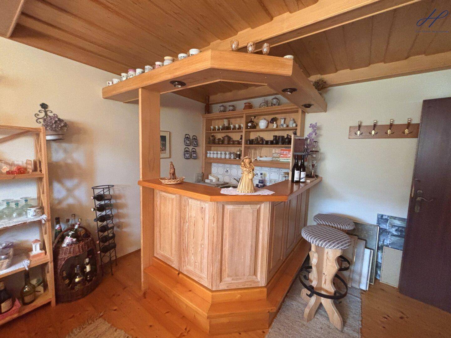 Hausbar im alpinen Stil mit Holzverkleidung und Regalen für Getränke.