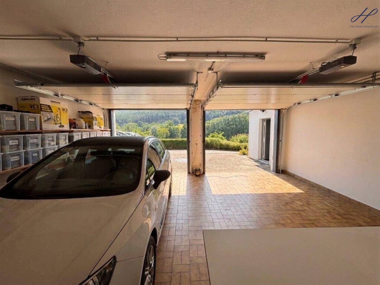 Doppelgarage mit geöffneten Toren und Blick auf die Landschaft.