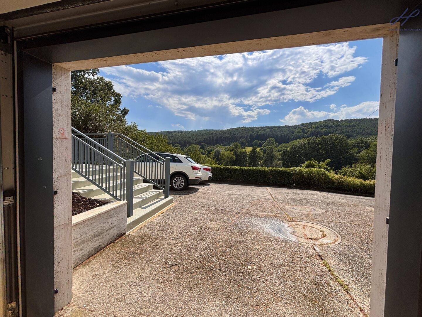 Außenparkplatz vor der Garage mit Treppenzugang zum Haus.