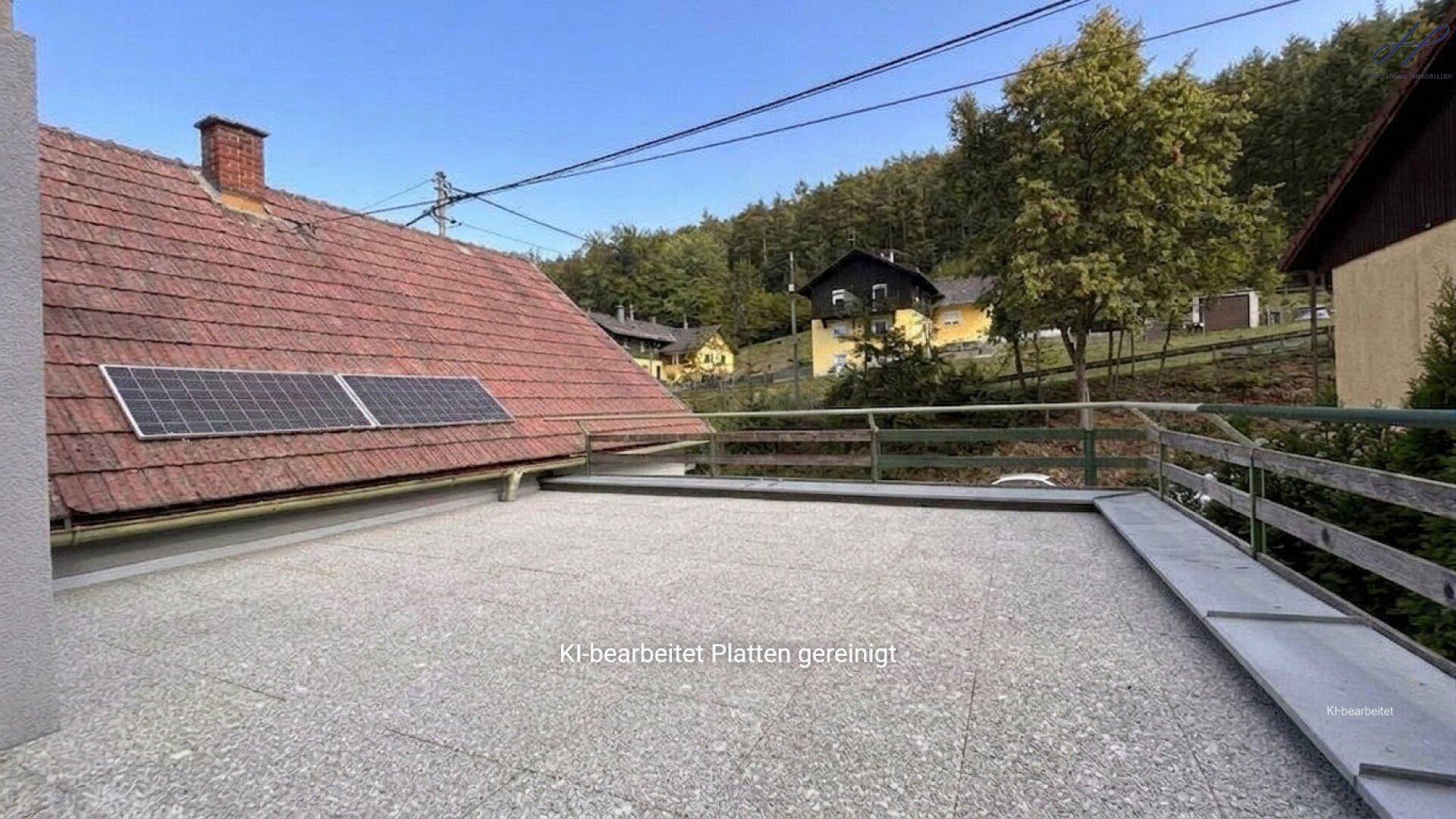 Große Dachterrasse mit Blick auf die Umgebung und Solarpaneele auf dem Nachbardach.