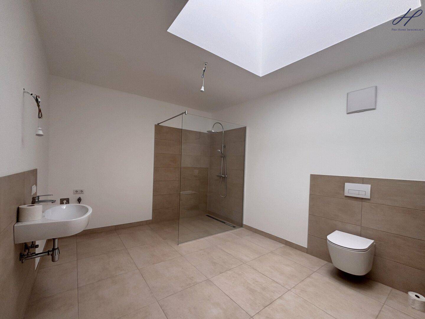 Modernes Badezimmer mit begehbarer Dusche, Wand-WC und Oberlicht für natürliches Licht.