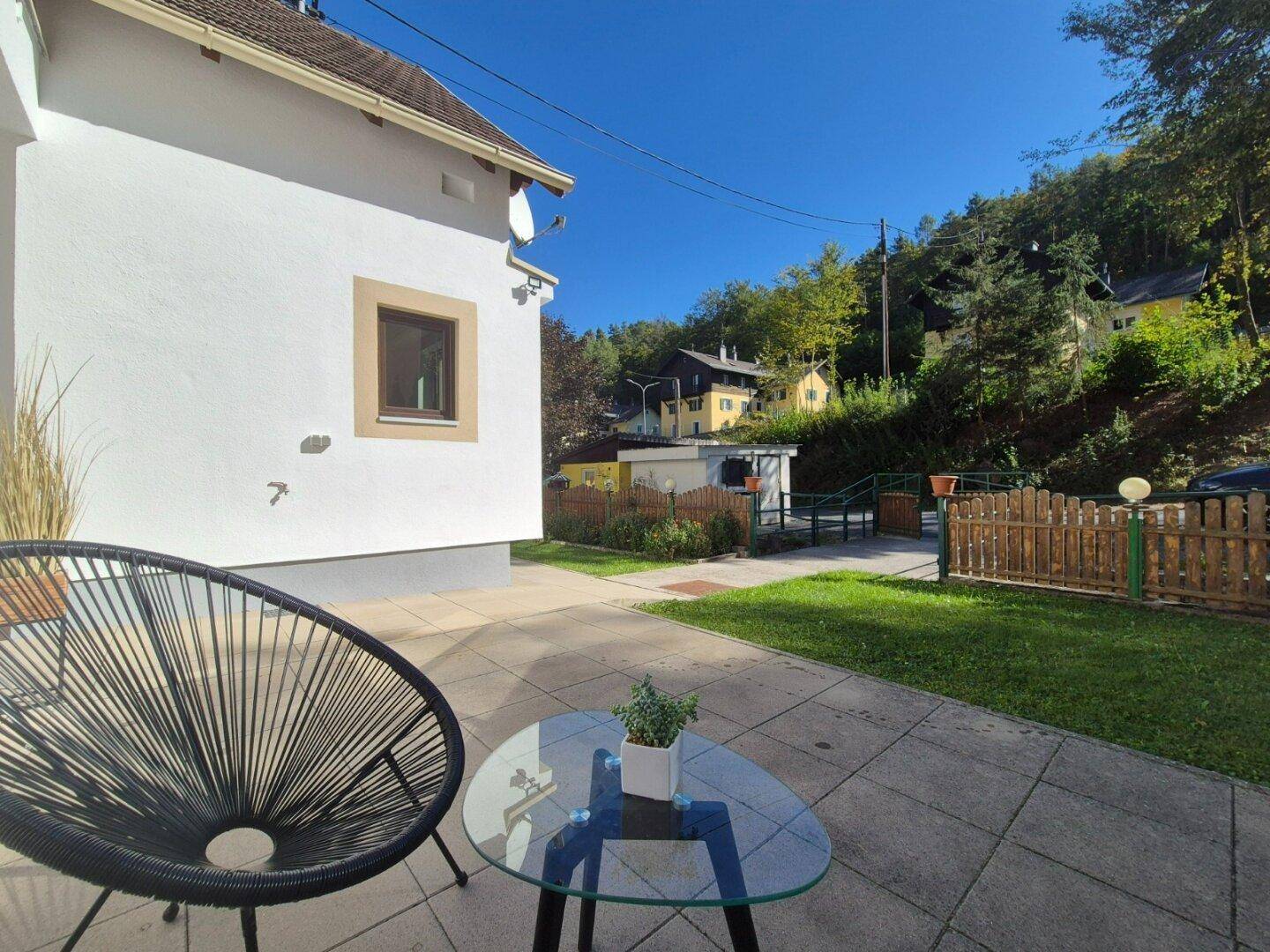 Gemütliche Terrasse mit modernen Gartenmöbeln und Blick auf den Gartenbereich.