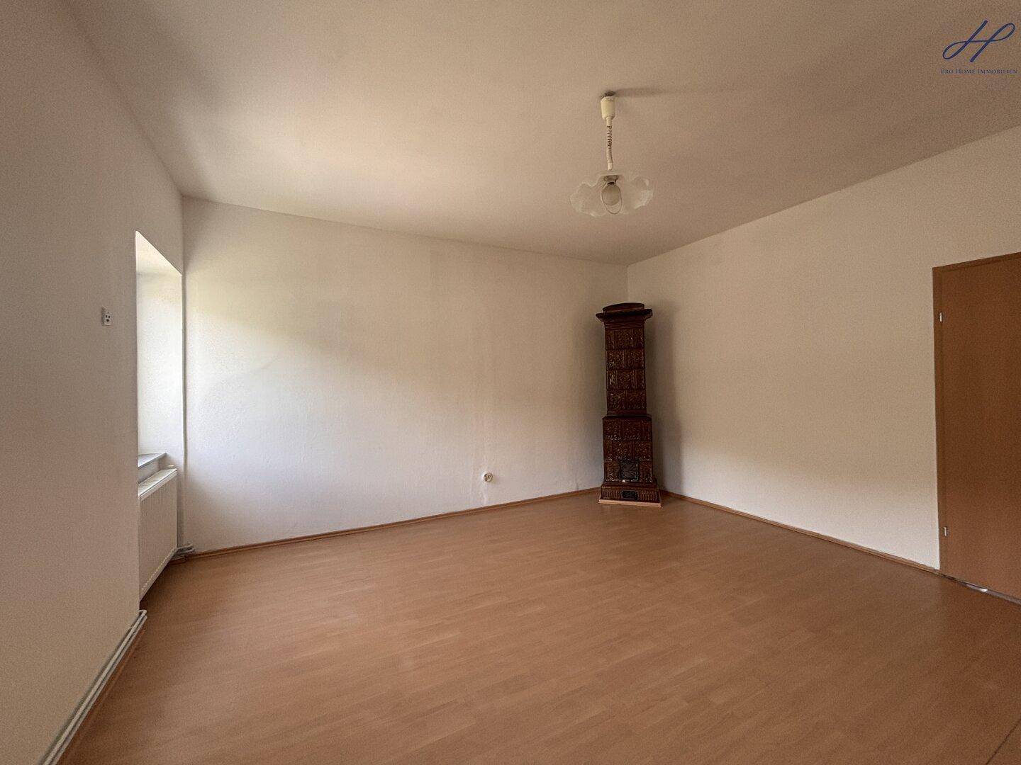 Heller Raum mit Laminatboden und einem dekorativen Eckschrank, bereit zur individuellen Gestaltung.