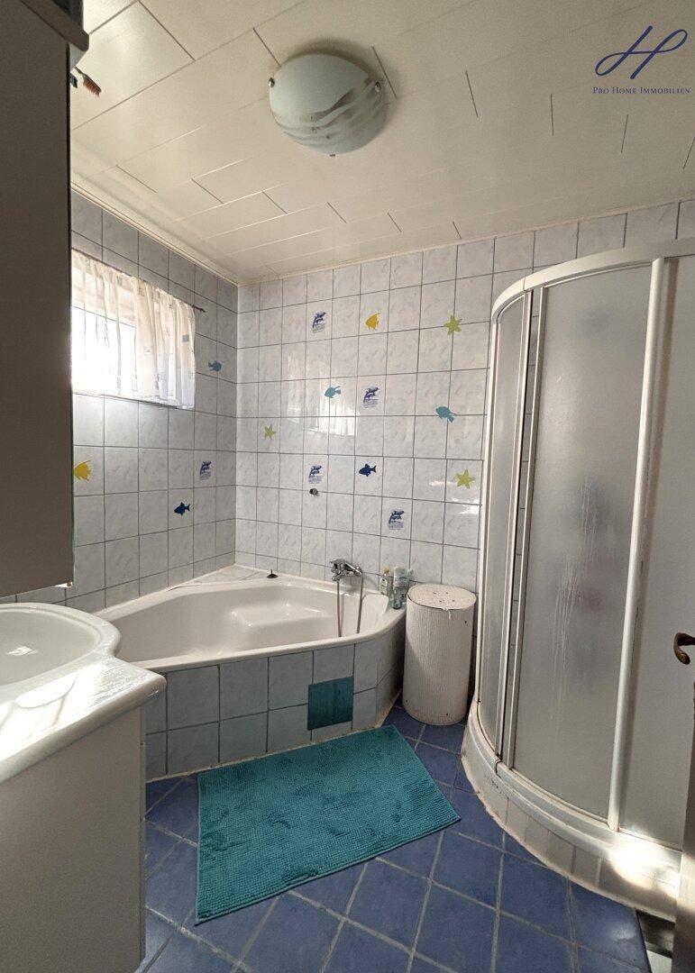 Buntes Badezimmer mit Eckbadewanne, Duschkabine und verspielten Fliesen.